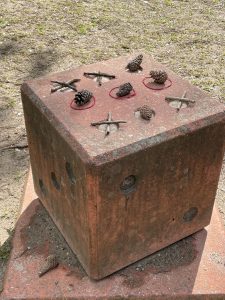 Ein Sitzquader aus Beton ist verziert wie ein Tick-Tack-Toe-Spiel
